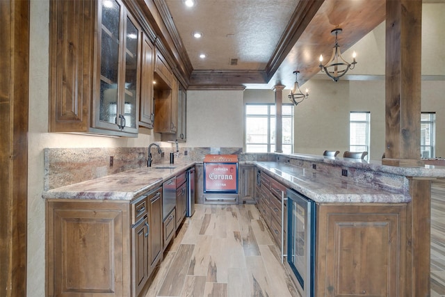 kitchen featuring crown molding, light wood-type flooring, beverage cooler, light stone counters, and pendant lighting