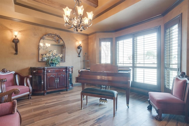 sitting room featuring a chandelier, crown molding, wood-type flooring, and a raised ceiling