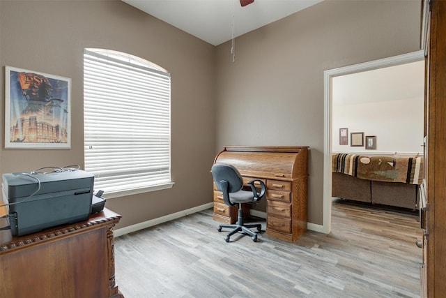 home office with light hardwood / wood-style floors and ceiling fan