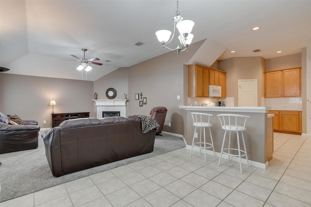 living room featuring light colored carpet, lofted ceiling, and ceiling fan with notable chandelier