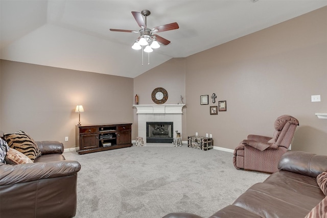 living room featuring carpet flooring, vaulted ceiling, a tiled fireplace, and ceiling fan