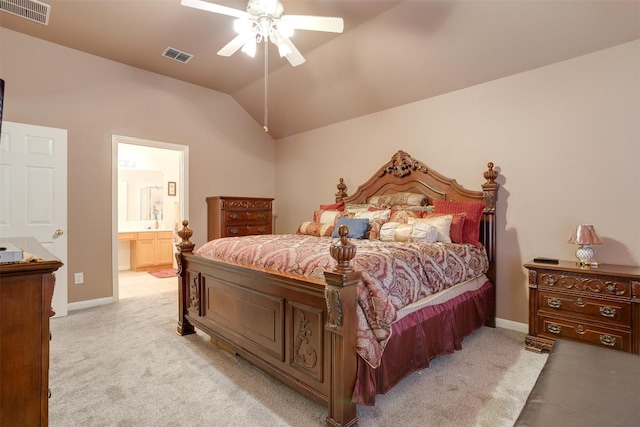 bedroom featuring vaulted ceiling, ceiling fan, light colored carpet, and ensuite bath