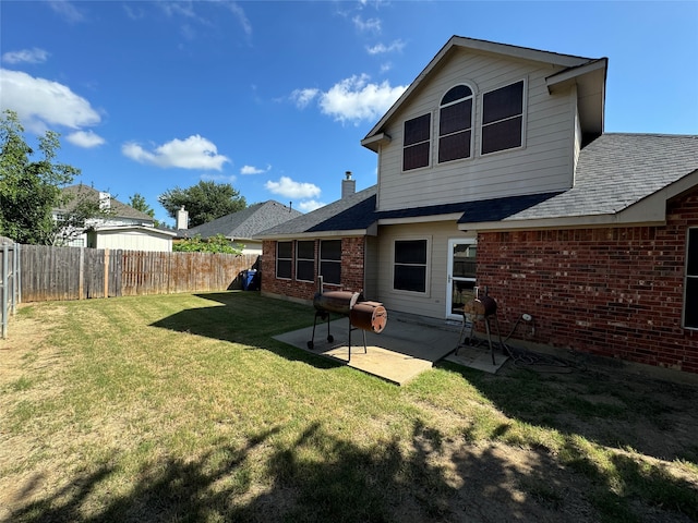 rear view of house with a yard and a patio area