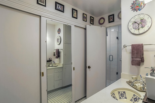 bathroom featuring an enclosed shower, vanity, and tile flooring