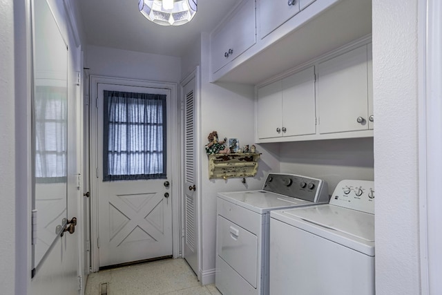 washroom with light tile flooring, cabinets, and washer and clothes dryer