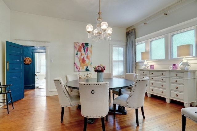 dining space with a chandelier, light hardwood / wood-style flooring, and ornamental molding