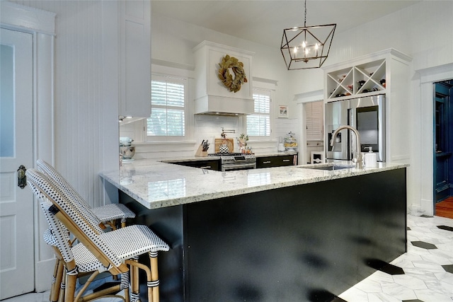 kitchen with decorative light fixtures, light hardwood / wood-style flooring, kitchen peninsula, stainless steel appliances, and a breakfast bar area