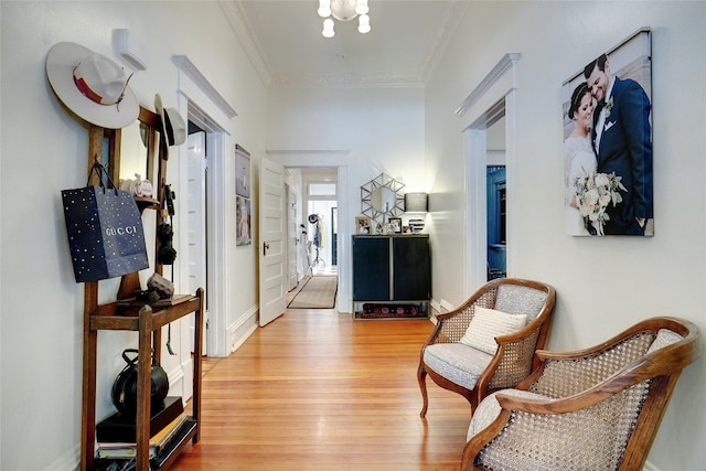 interior space with a notable chandelier, light hardwood / wood-style flooring, and crown molding