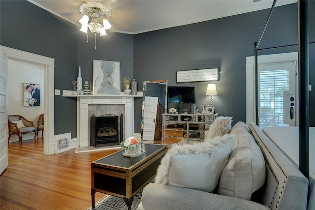 living room with ceiling fan, light hardwood / wood-style flooring, and crown molding