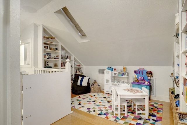 recreation room featuring lofted ceiling and hardwood / wood-style floors