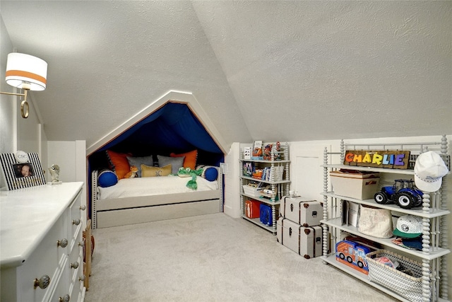 bedroom featuring lofted ceiling, a textured ceiling, and light colored carpet