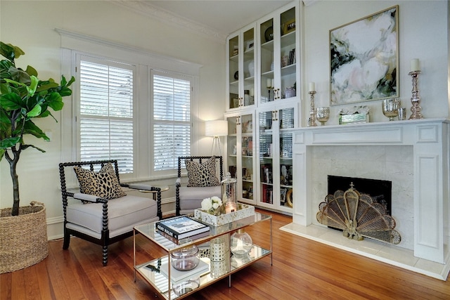 interior space featuring a premium fireplace, ornamental molding, and hardwood / wood-style flooring