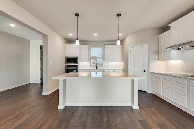 kitchen with under cabinet range hood, dark wood finished floors, built in microwave, light countertops, and stainless steel oven