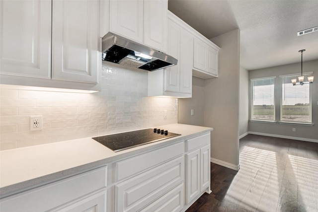 kitchen with visible vents, light countertops, white cabinets, under cabinet range hood, and black electric cooktop