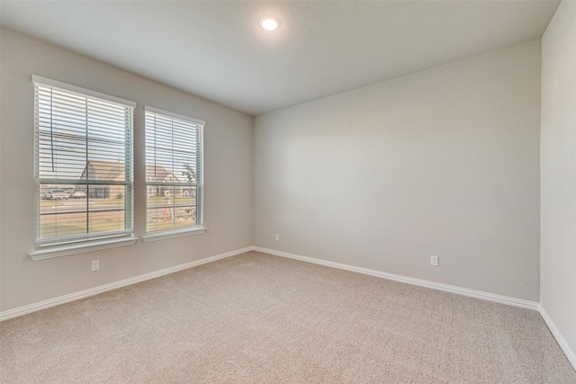 spare room featuring recessed lighting, carpet, and baseboards