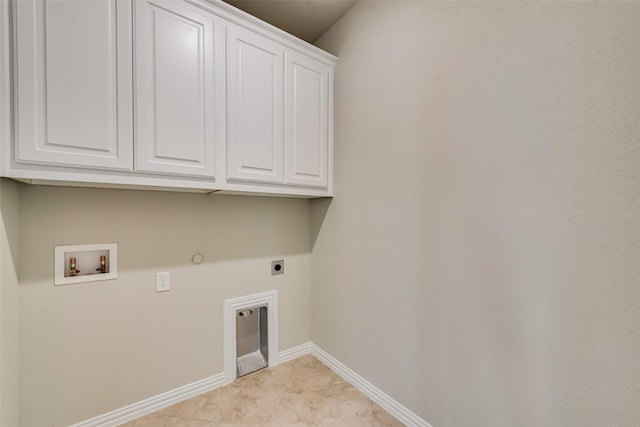 clothes washing area with electric dryer hookup, washer hookup, cabinet space, baseboards, and gas dryer hookup