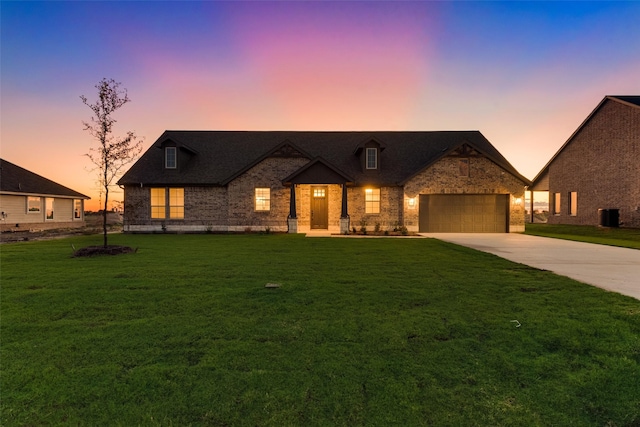 view of front of house with central AC unit, driveway, an attached garage, a lawn, and brick siding