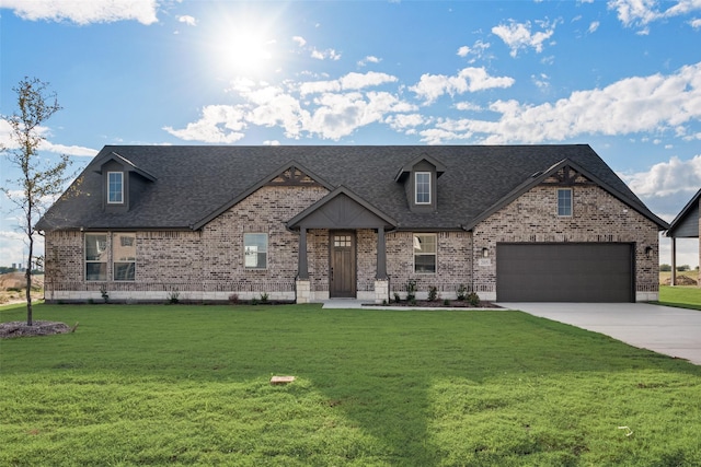 view of front of house featuring a front yard, brick siding, roof with shingles, and driveway