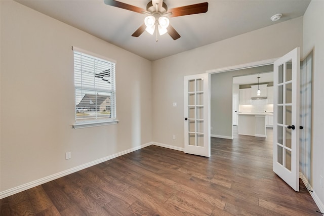 spare room with french doors, baseboards, dark wood-type flooring, and ceiling fan