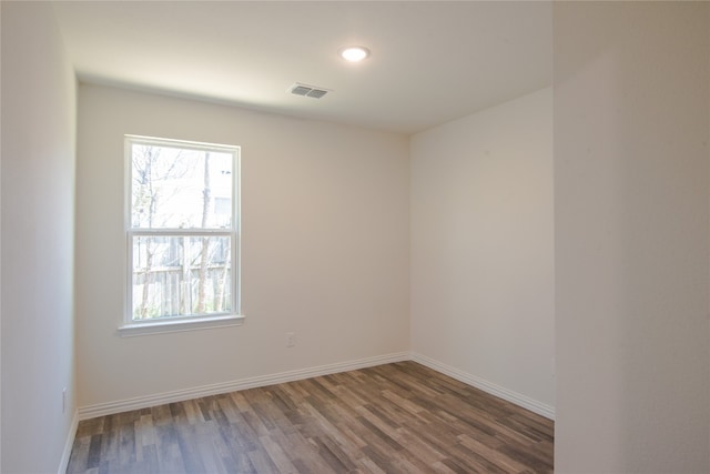 empty room with dark hardwood / wood-style floors and a wealth of natural light