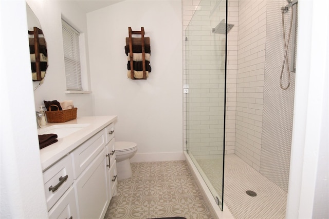 bathroom featuring a shower with door, tile floors, toilet, and vanity