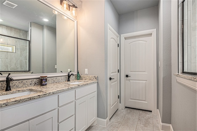 bathroom with vanity with extensive cabinet space, double sink, and tile floors