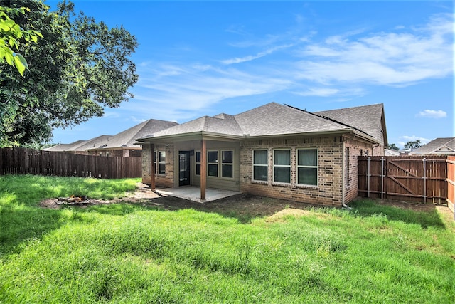 rear view of house featuring a patio area and a yard