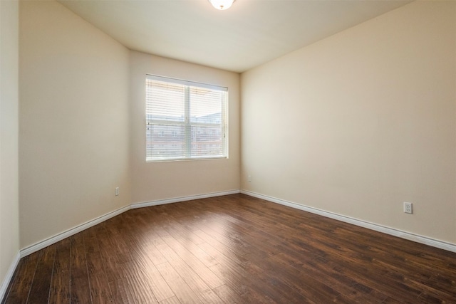 unfurnished room with dark wood-type flooring