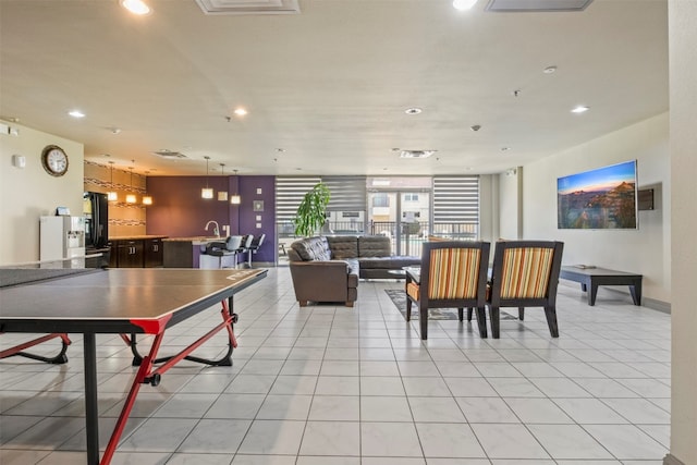 recreation room featuring sink and light tile floors