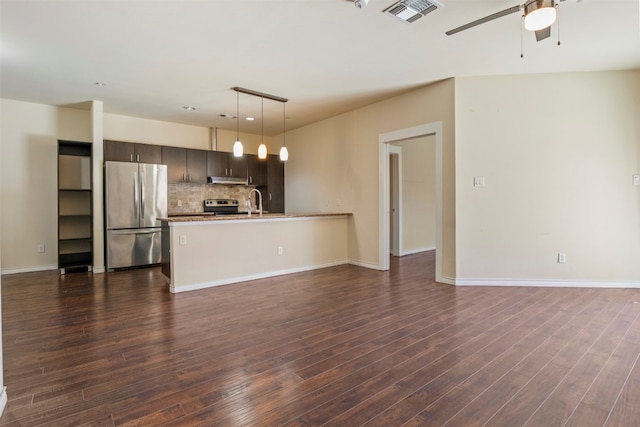 interior space featuring backsplash, ceiling fan, dark wood-type flooring, dark brown cabinetry, and stainless steel refrigerator