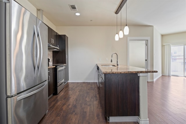 kitchen with stainless steel appliances, decorative light fixtures, sink, dark hardwood / wood-style floors, and light stone counters