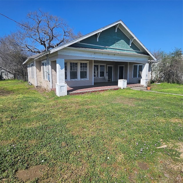 back of house with a yard and covered porch