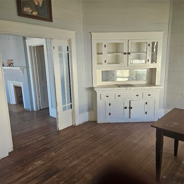 bar with white cabinetry and dark hardwood / wood-style floors