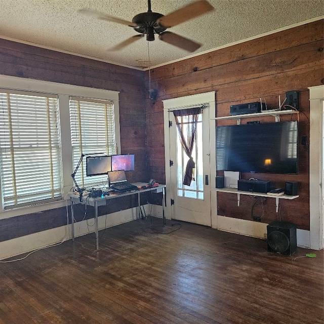 office area with plenty of natural light, dark hardwood / wood-style floors, ceiling fan, and wood walls