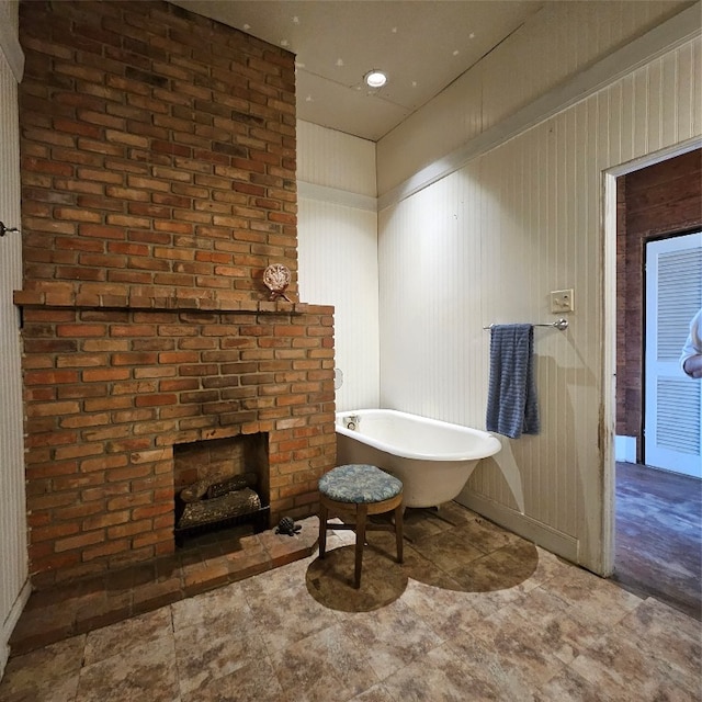 bathroom featuring tile floors, a bathtub, and a brick fireplace