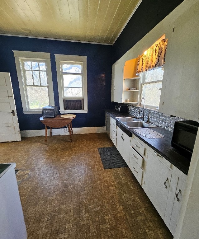 kitchen featuring white cabinets, backsplash, sink, and wood ceiling