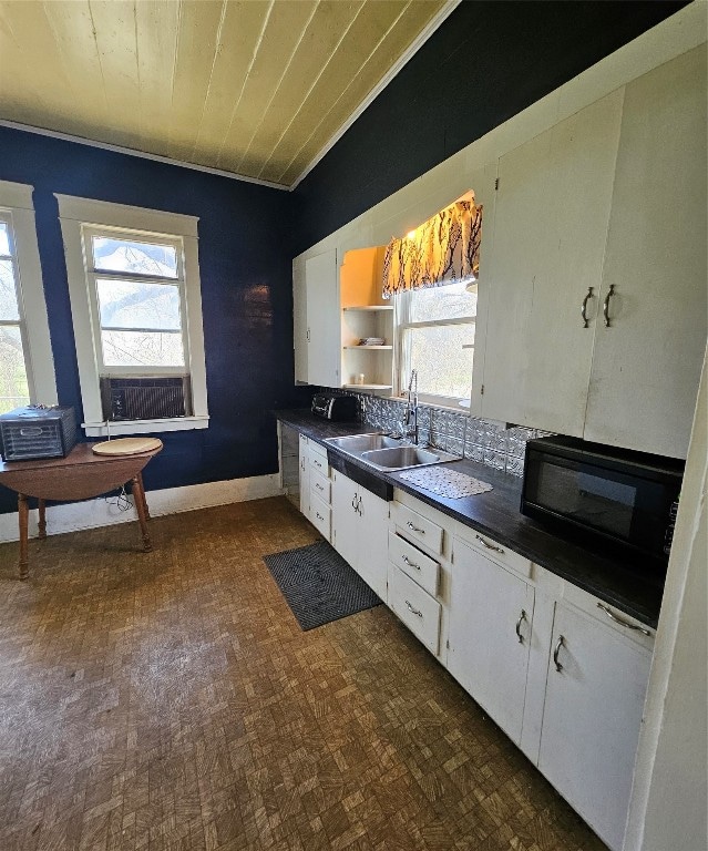 kitchen with backsplash, ornamental molding, white cabinets, and sink