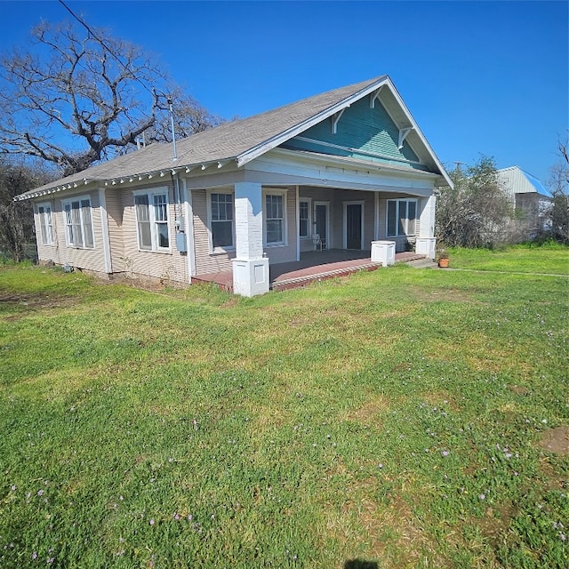 rear view of house featuring a lawn