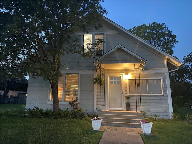 bungalow-style home with a yard