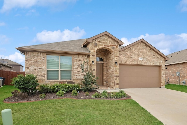 view of front of property with a garage, driveway, fence, a front yard, and brick siding