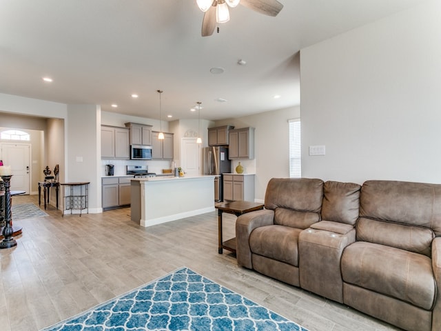 living room featuring light hardwood / wood-style flooring and ceiling fan