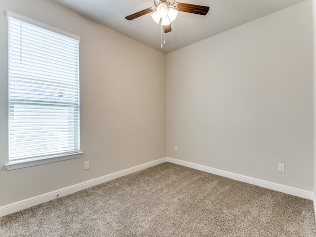 carpeted spare room featuring ceiling fan