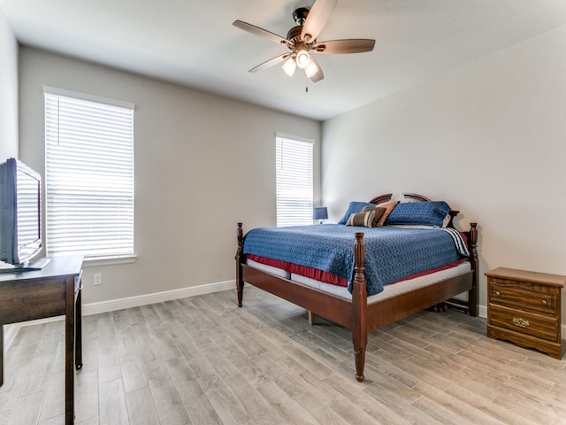 bedroom with ceiling fan, light wood-type flooring, and multiple windows