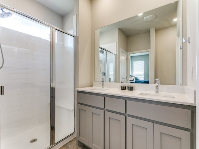 bathroom with vanity, a shower with door, and a wealth of natural light