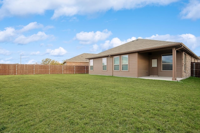 back of property with a yard and a patio