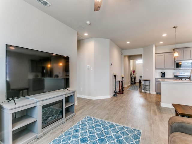 living room featuring light wood-type flooring and ceiling fan