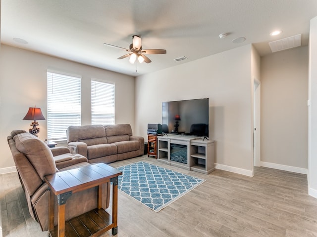 living room featuring ceiling fan and light hardwood / wood-style flooring