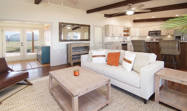 tiled living room featuring beamed ceiling, a wealth of natural light, ceiling fan, and french doors