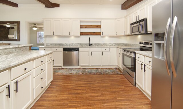 kitchen with ceiling fan, white cabinetry, beam ceiling, stainless steel appliances, and hardwood / wood-style flooring