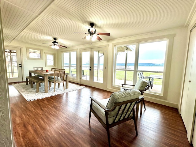 sunroom with a water view, a wealth of natural light, ceiling fan, and french doors